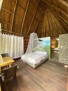 a bedroom with a bed in a straw hut at Ecohab -Parque Tayrona in Santa Marta