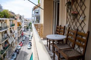 einen Tisch und Stühle auf einem Balkon mit Stadtblick in der Unterkunft Acropolis rooftop view, 200m from Neos kosmos metro station in Athen