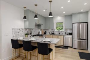 a kitchen with a large island with black chairs at Spacious Fully Furnished 2-BR Suite in Vancouver