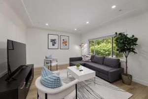 ein Wohnzimmer mit einem Sofa und einem TV in der Unterkunft Spacious Fully Furnished 2-BR Suite in Vancouver