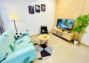 Kampong Pantai DusunにあるNetflix-Seaview-SunsetView-PuteriBeach-Mutiara Beach Resort Melakaのリビングルーム(青いソファ、テレビ付)