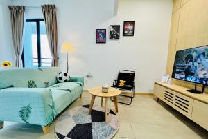 sala de estar con sofá azul y TV en Netflix-Seaview-SunsetView-PuteriBeach-Mutiara Beach Resort Melaka en Kampong Pantai Dusun