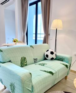 Kampong Pantai Dusun的住宿－Netflix-Seaview-SunsetView-PuteriBeach-Mutiara Beach Resort Melaka，客厅里一张沙发上放足球球