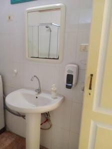 Baño blanco con lavabo y espejo en Casa Escuela, en Valle Gran Rey