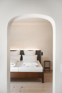 Bett mit weißer Bettwäsche und Kissen in einem Zimmer in der Unterkunft Gasthof Zantl in Bad Tölz