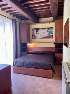 - une chambre avec un lit orné d'une peinture murale dans l'établissement Saturnia House, à Poggio Murella