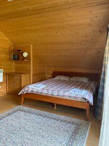 um quarto com uma cama num chalé de madeira em Садиба Свидюків em Staryy Mizunʼ