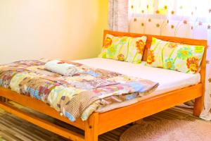 a bed with a wooden frame and pillows on it at Haven Luxury Homes in Kitengela 