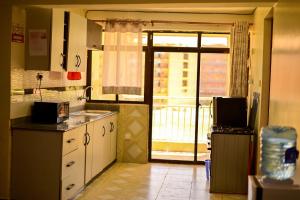 a kitchen with a sink and a door to a balcony at Haven Luxury Homes in Kitengela 