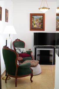 a living room with two chairs and a television at Hermoso departamento céntrico en Bahía Blanca in Bahía Blanca