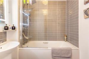 a bathroom with a bath tub and a sink at Fullers Modern and Stylish Room in Chudleigh +14 photos