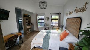 1 dormitorio con 1 cama, escritorio y ventanas en Harbour Delight & Harbour Comfort, en Ciudad del Cabo