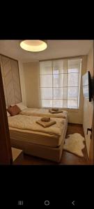 a small bedroom with two beds and a light at Apartman Bagic in Zlatibor