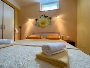 a bedroom with a large bed with towels on it at Apartments Korta in Račišće