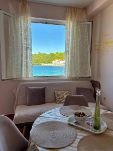 a living room with a couch and a window at Apartments Korta in Račišće