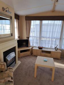 a living room with a fireplace and a tv at Seaview in Skegness