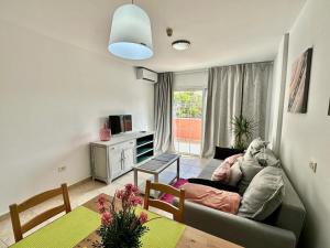 a living room with a couch and a table at Sunny Apartment & Heated pool in Los Cristianos