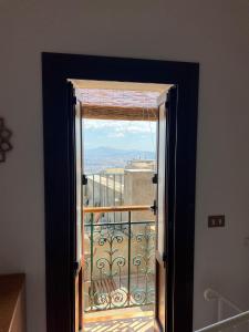 una puerta abierta a un balcón con vistas en La Chiocciola - Casa vacanze, en Erice