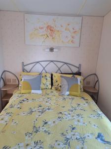 a bedroom with a bed with a yellow blanket and pillows at Seaview in Skegness