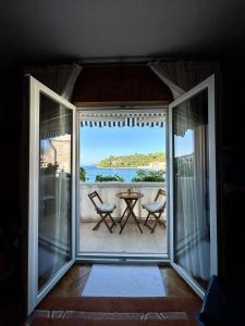an open door to a balcony with a table and chairs at Apartments Korta in Račišće