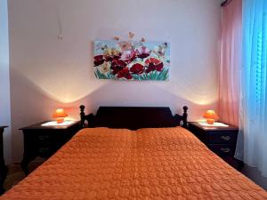 a bedroom with a orange bed with two nightstands and two lamps at Apartments Korta in Račišće