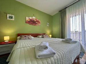 a bedroom with a large bed with towels on it at Apartments Korta in Račišće