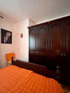 a bedroom with a bed and a large wooden cabinet at Apartments Korta in Račišće