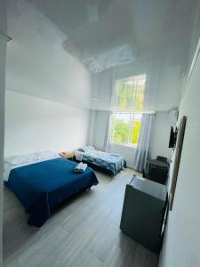 BLUE ISLAND HOTEL في سان أندريس: غرفة نوم بسريرين ونافذة