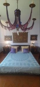 a bedroom with a large bed with a chandelier at La stanza di Vema in Massarosa