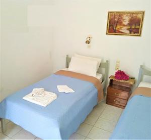 a small bedroom with a blue bed and a night stand at Valentino in Kalymnos