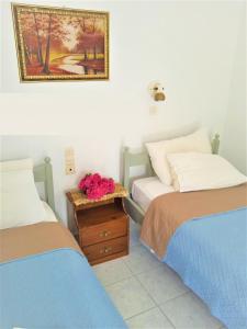 a bedroom with two beds and a table with flowers on it at Valentino in Kalymnos
