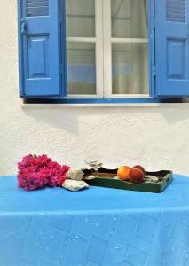 a tray of fruit and a glass of wine and flowers at Valentino in Kalymnos