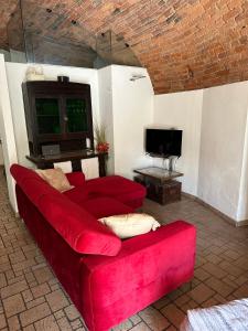 a living room with a red couch and a tv at CASA DI LUCA in Stezzano