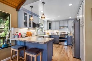 a kitchen with blue cabinets and a large island with bar stools at Water's Edge - Gorgeous Water Views! home in Groveland