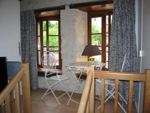 a dining room with a table and chairs and windows at Faubourg St Jean in Aubeterre-sur-Dronne