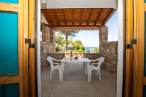 a table and chairs on the porch of a house at George Seaside Serviced Studios & Apartments in Pefki
