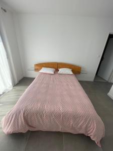 a pink bed with a wooden headboard in a room at Magnifique villa haut standing in Gignac