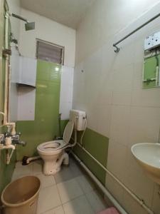 a bathroom with a toilet and a sink at Malwade Motel in Pune