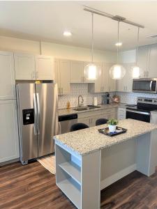 a kitchen with white cabinets and a stainless steel refrigerator at 1 BR w Balcony View Resort Pool Free Parking in Addison