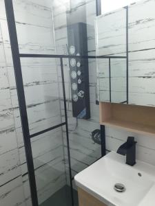 baño con espejo y lavabo blanco en Cozy Studio Onesti, en Onești
