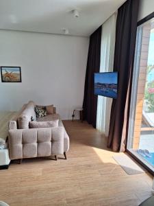 Sea Breeze White Villas 2 في بيلغاه: غرفة معيشة مع أريكة وتلفزيون بشاشة مسطحة
