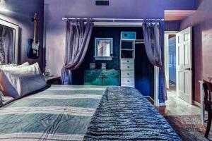 1 dormitorio con cama y pared púrpura en Boho Chic Malibu Retreat Estate Salt Pool + Yoga, en Malibú