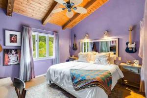 1 dormitorio con 1 cama y paredes moradas en Boho Chic Malibu Retreat Estate Salt Pool + Yoga, en Malibú