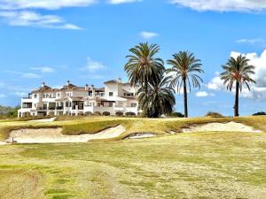 una casa en la cima de una colina con palmeras en La Casa Rosita, Hacienda Riquelme Golf Resort Sucina en Murcia