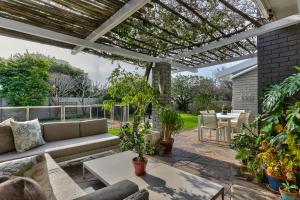 a patio with a couch and a table with plants at Maple Residence in Cape Town