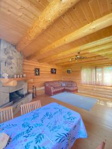 a room with a table and a couch in a log cabin at Садиба Краєвських in Krapivnik