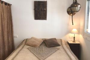 a bedroom with a bed and a lamp and a window at Estudio moderno, coqueto, céntrico y muy funcional in Tarifa