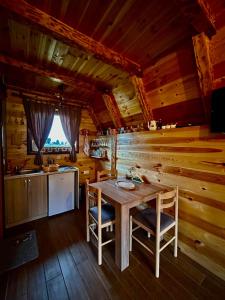 una cocina con mesa y sillas en una cabaña en Mountain house Drveni Raj en Žabljak