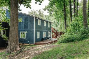 a green house in the woods with a tree at Harmony Ridge Hideaway: mountain retreat w/hot tub in Front Royal