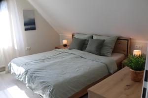 1 dormitorio con 1 cama con 2 lámparas y una planta en Ferienwohnung Ostfrieslandliebe, en Südbrookmerland